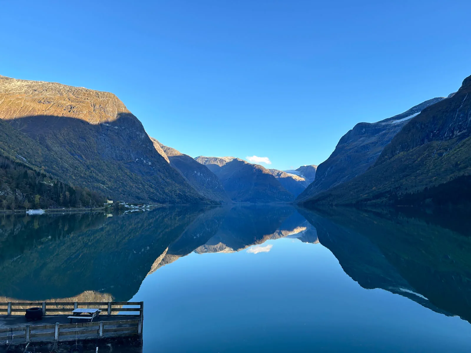 Calm water between mountains beneath a blue sky