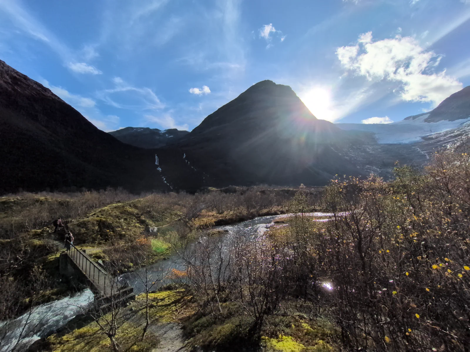 Stream between mountain slopes in the sunlight