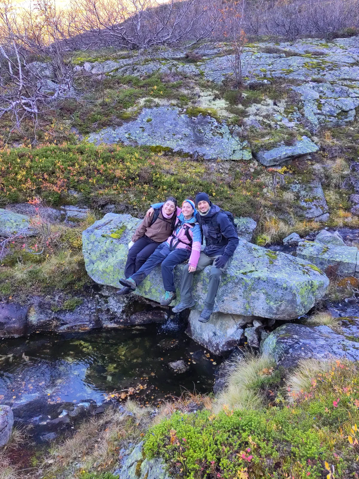 Group members cross a stream over stones
