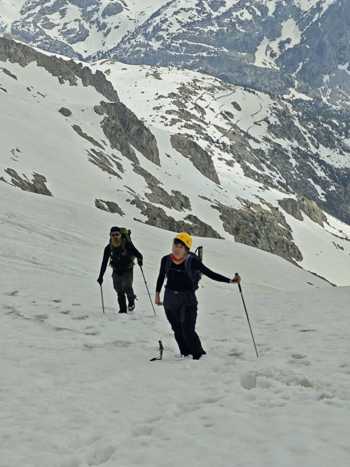 Two group members climb a snow-covered slope