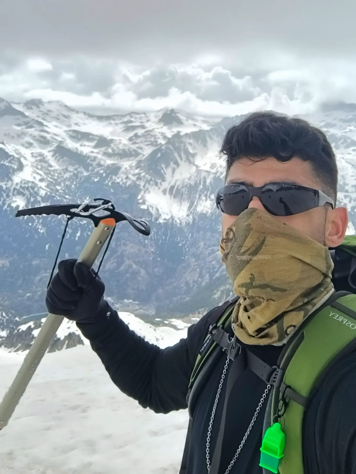 Self-portrait with an ice axe and the snow-covered Pyrenees behind