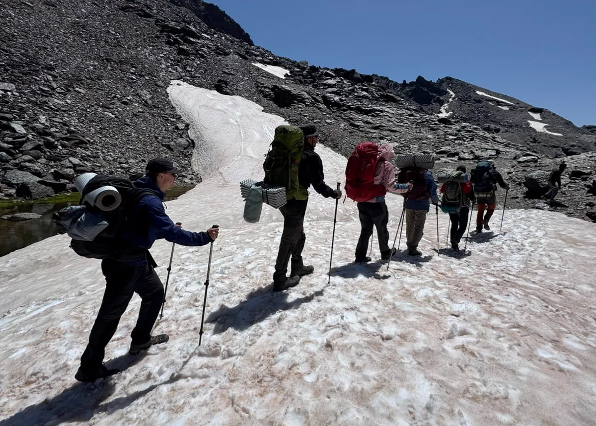 The group crosses a snowfield during the Sierra Nevada traverse