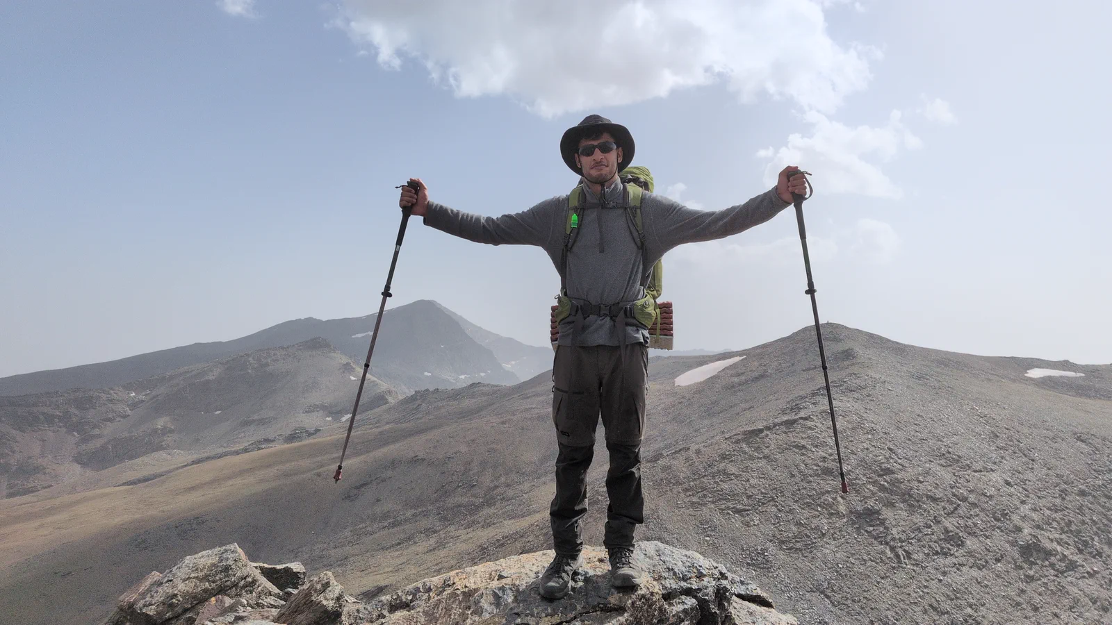 A mountaineer looks across Sierra Nevada from a rocky summit