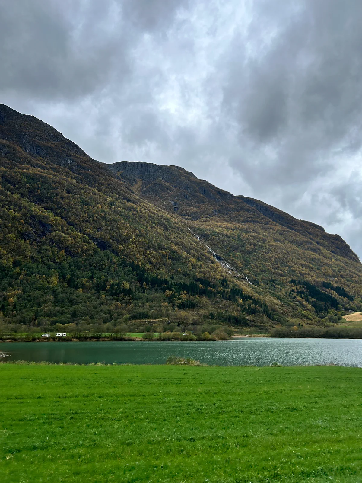 Lago y ladera de montaña bajo las nubes