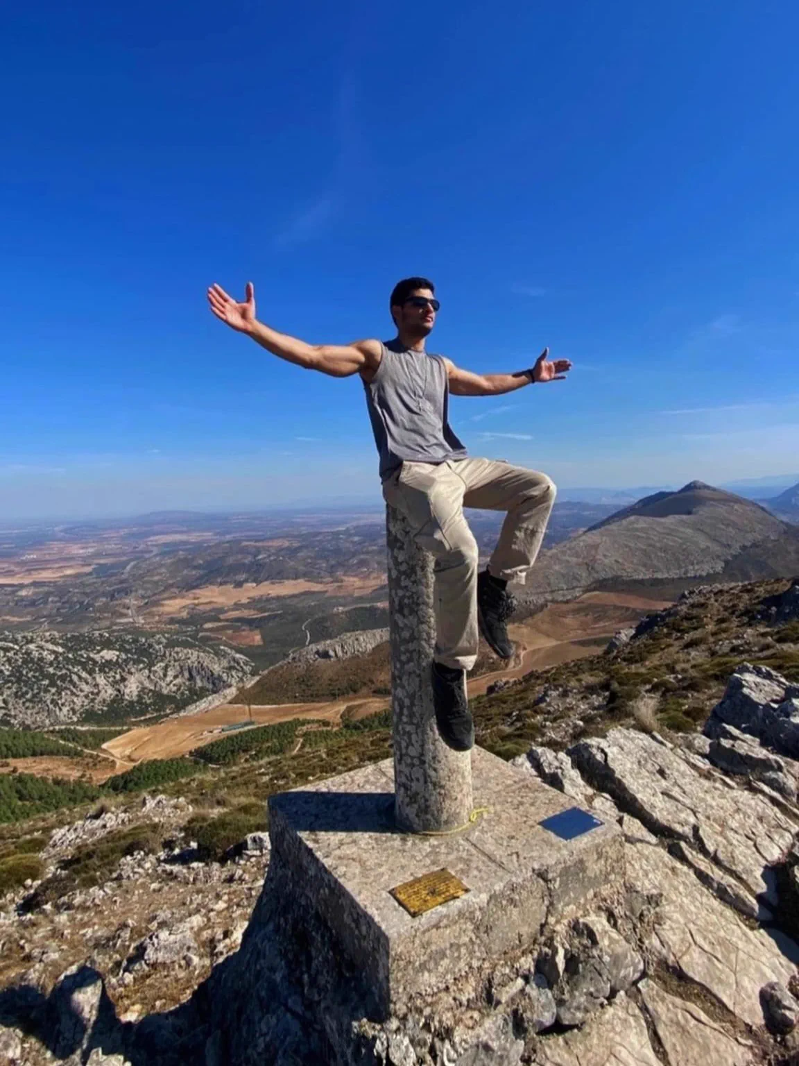 Bauti on the Pico Huma trig point with the Málaga landscape behind him