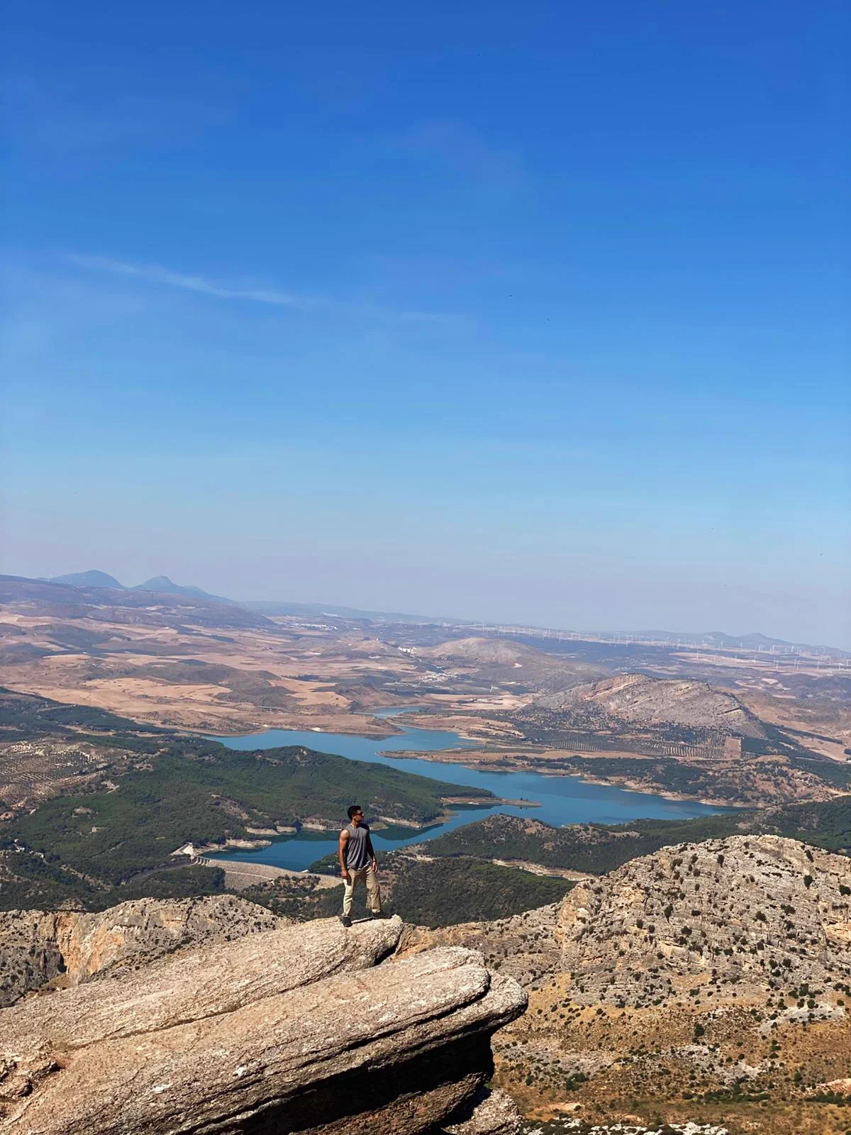 Bauti standing on the Púlpito with the El Chorro reservoirs behind him