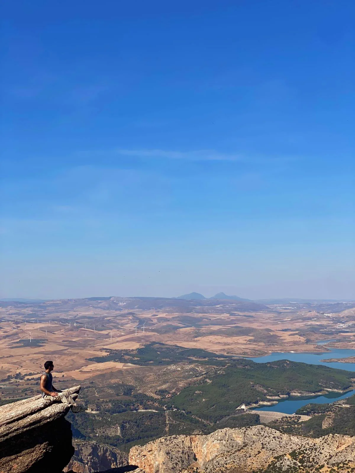 Bauti sitting at the tip of the Púlpito above the El Chorro landscape