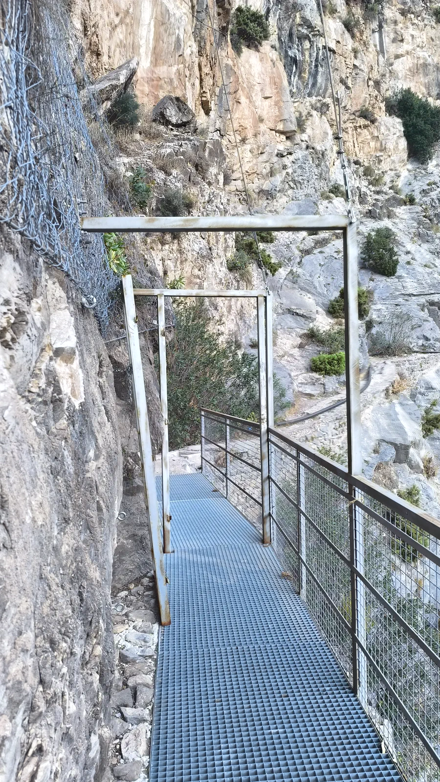 Metal walkway beside a vertical rock wall