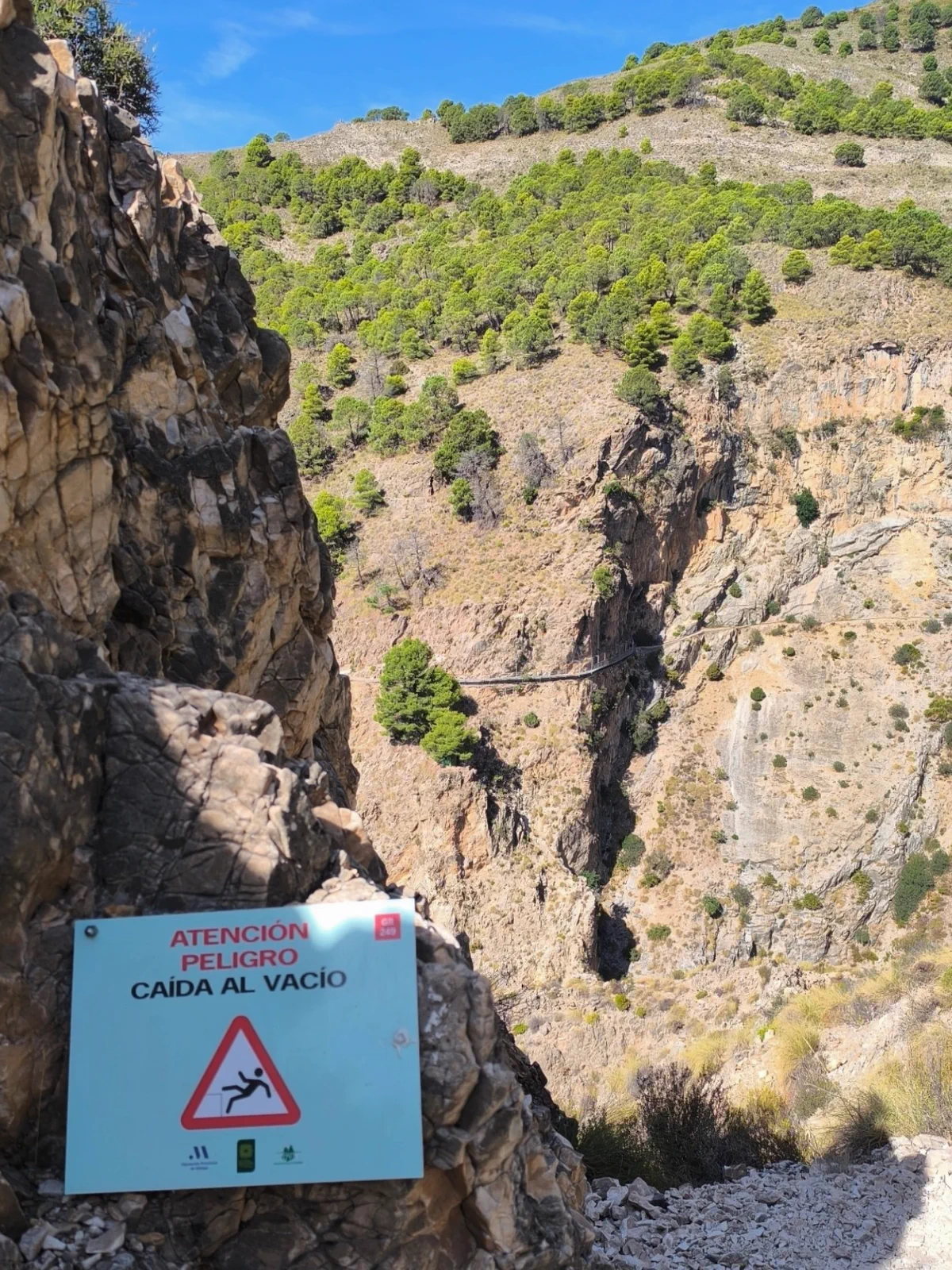 Saltillo suspension bridge beside a falling-hazard sign
