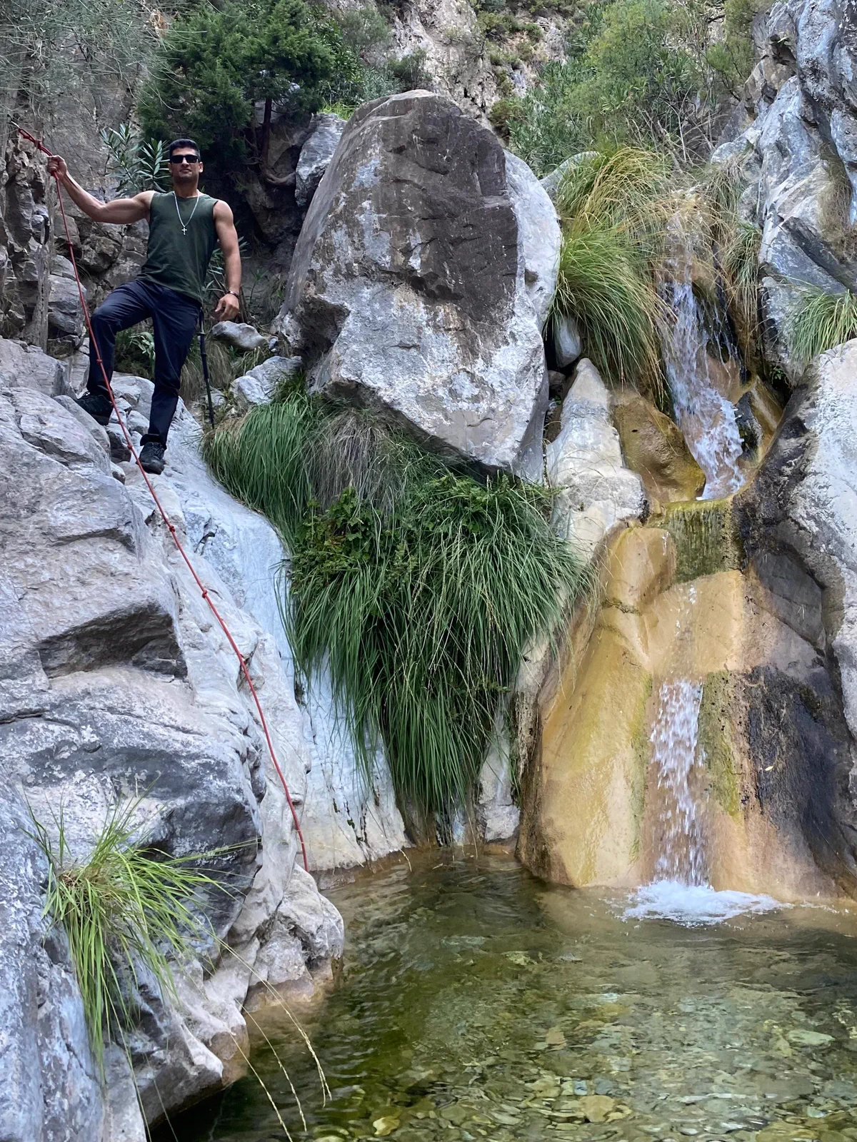 Hiker negotiating a rock passage beside the stream