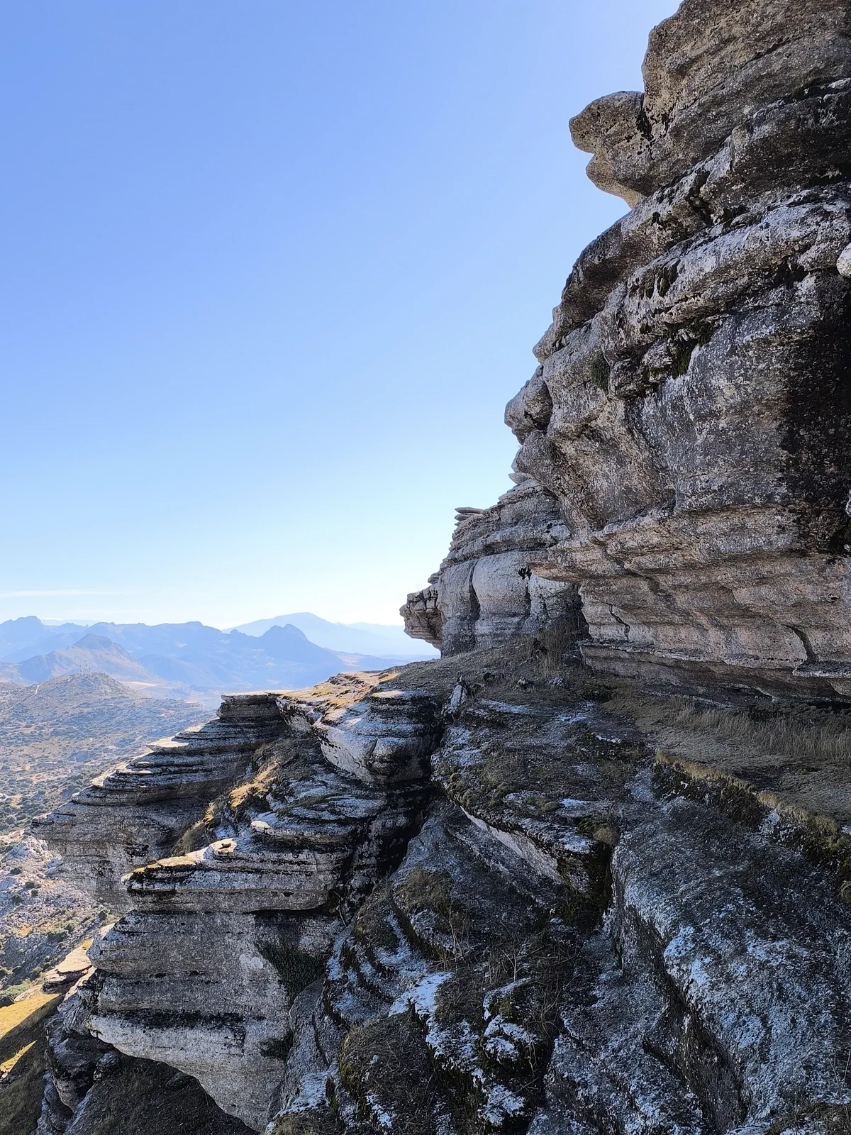 Open valley view beside a layered rock wall